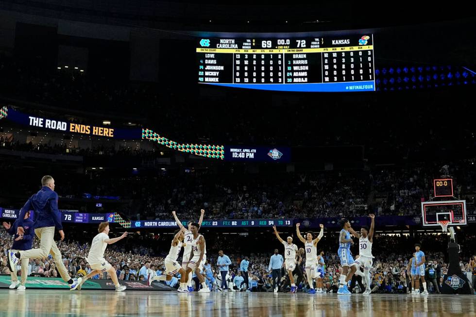 Kansas players celebrate a win over North Carolina after a college basketball game in the final ...