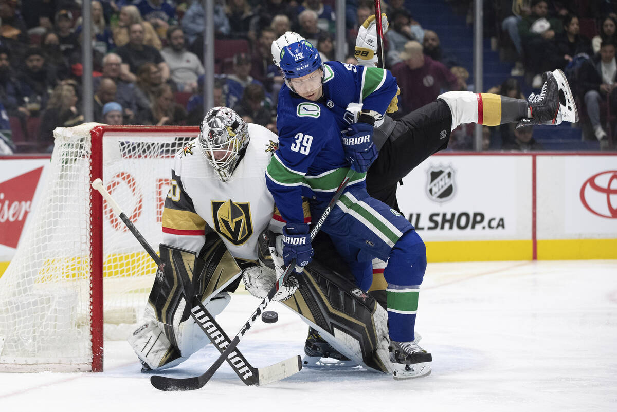 Vancouver Canucks' Alex Chiasson (39) is checked by Vegas Golden Knights' Shea Theodore, back, ...