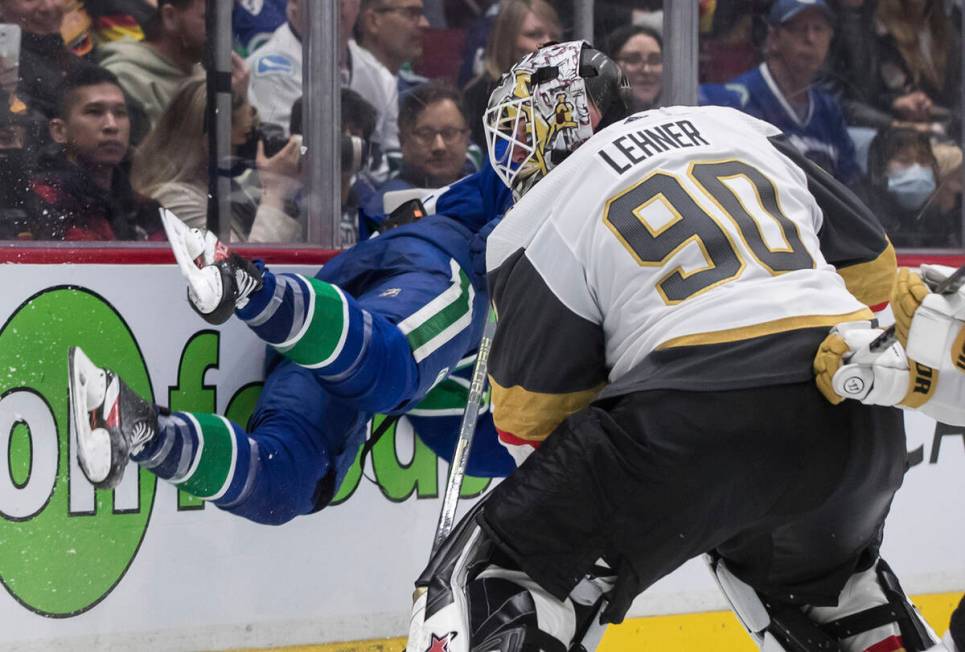 Vegas Golden Knights goalie Robin Lehner trips Vancouver Canucks' Jason Dickinson, back, during ...