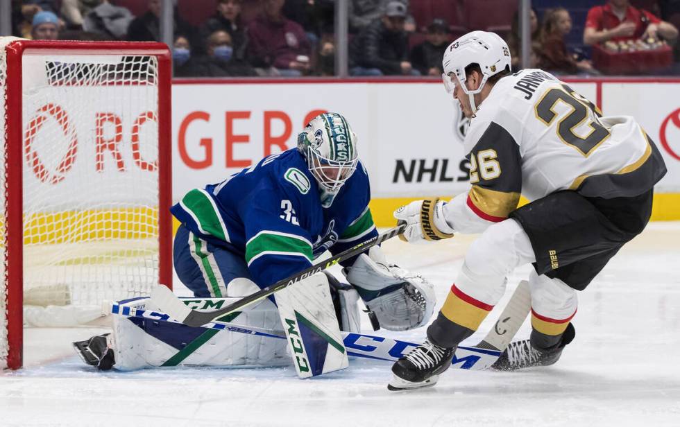 Vancouver Canucks goalie Thatcher Demko, left, stops Vegas Golden Knights' Mattias Janmark, of ...