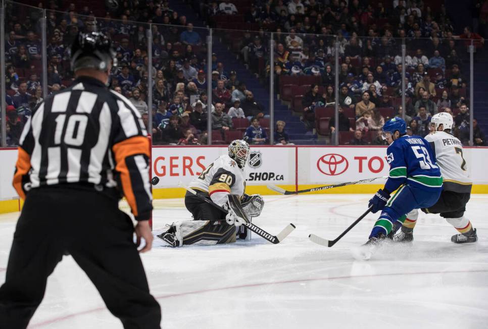 Vancouver Canucks' Bo Horvat (53) is stopped by Vegas Golden Knights goalie Robin Lehner (90), ...