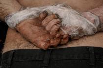 A lifeless body of a man with his hands tied behind his back lies on the ground in Bucha, Ukrai ...