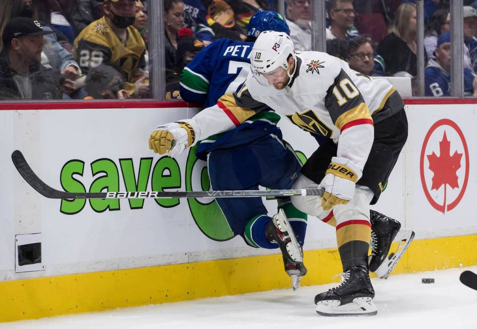 Vegas Golden Knights' Nicolas Roy (10) checks Vancouver Canucks' Nic Petan (7) during the third ...