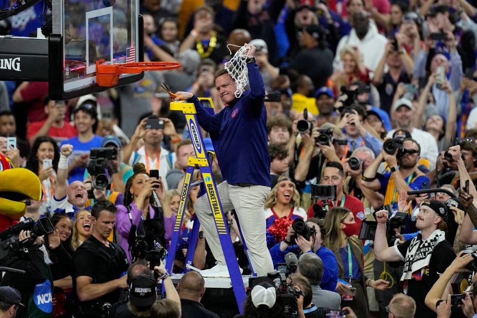 Kansas head coach Bill Self holds the net after a college basketball game in the finals of the ...
