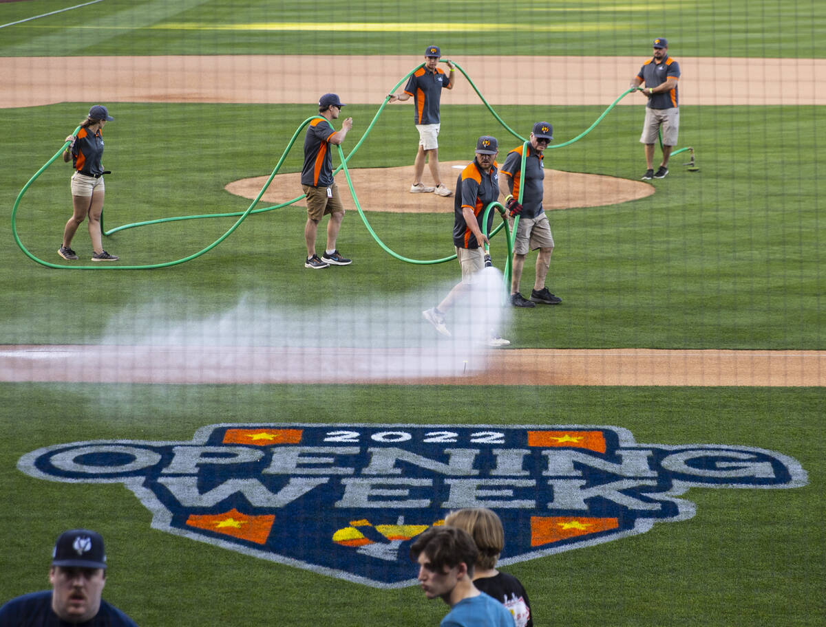 Ground crew work on the field prior to the start of the Las Vegas Aviators home opener game aga ...