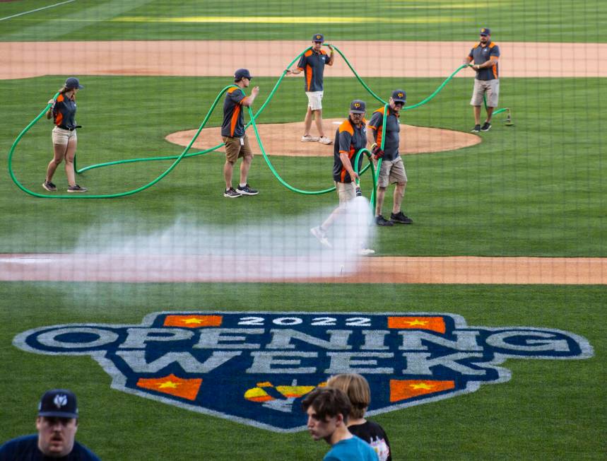 Ground crew work on the field prior to the start of the Las Vegas Aviators home opener game aga ...