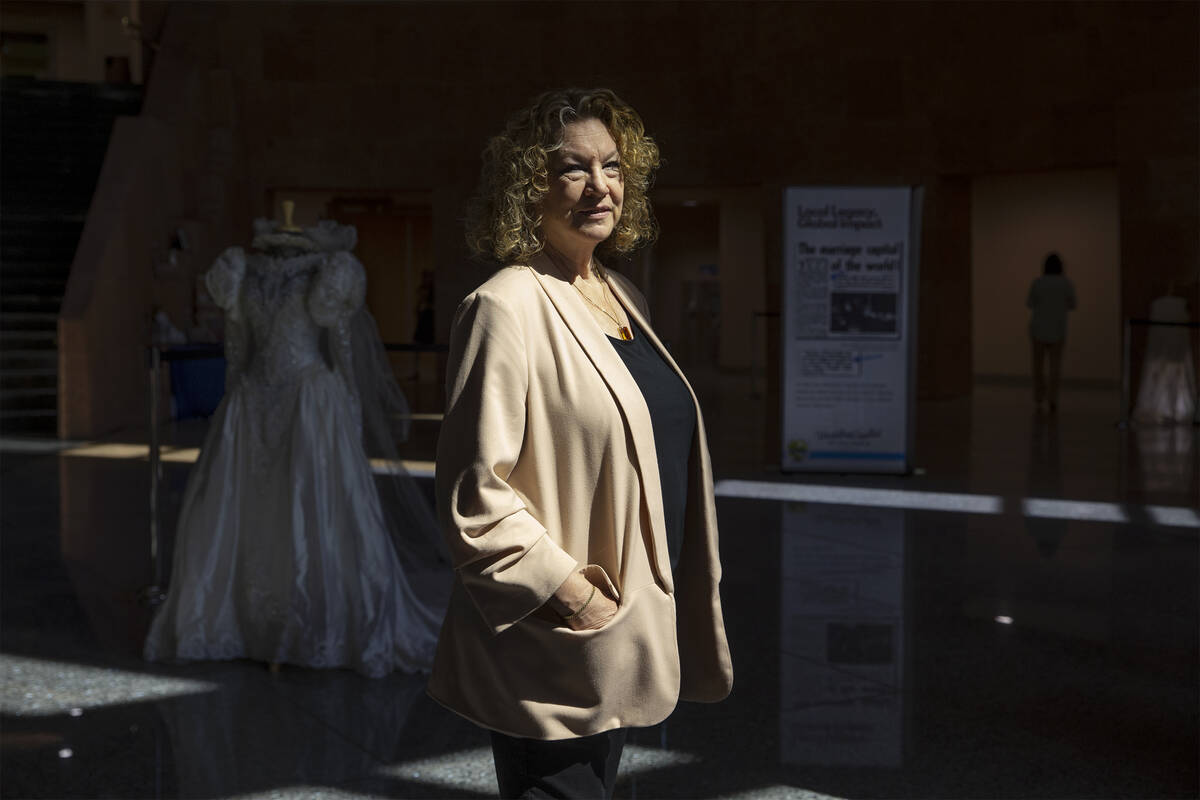 Clark County Clerk Lynn Goya poses for a portrait next to a historical wedding exhibit in the r ...