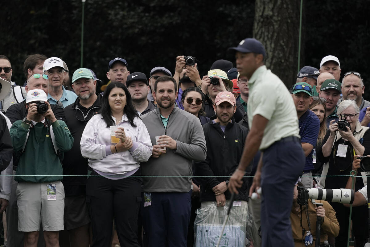 Spectators watch Tiger Woods on the driving range during a practice round for the Masters golf ...