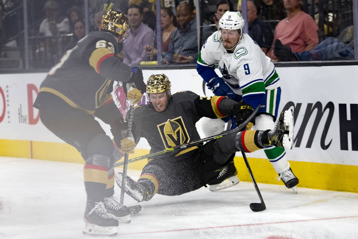 Golden Knights right wing Evgenii Dadonov (63) and Canucks center J.T. Miller (9) fight for the ...