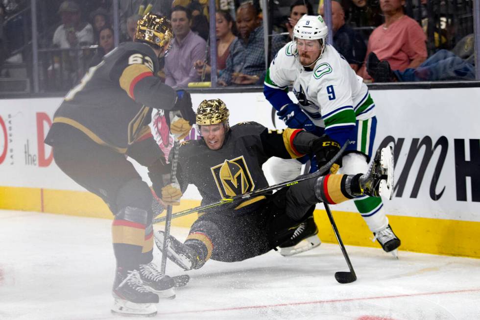 Golden Knights right wing Evgenii Dadonov (63) and Canucks center J.T. Miller (9) fight for the ...