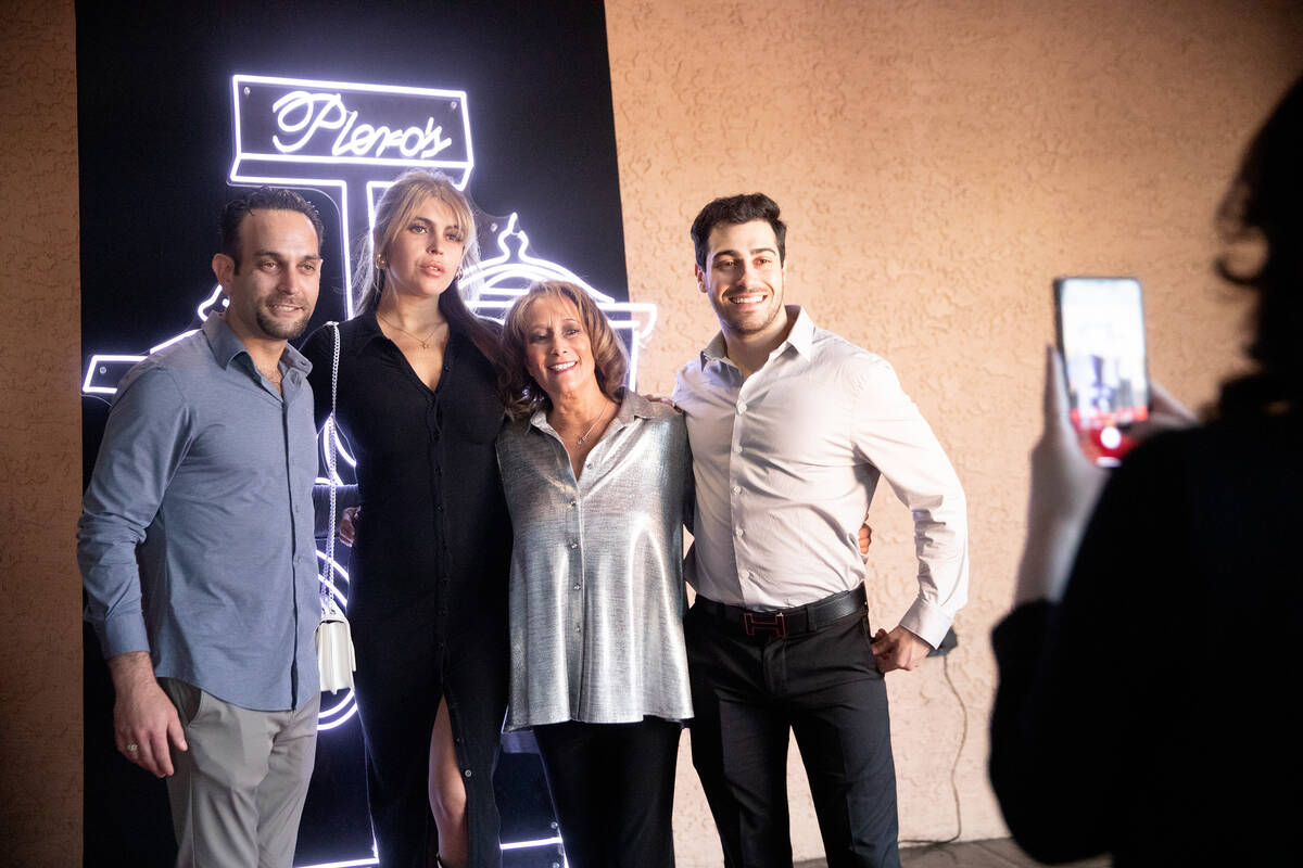 Guests taking photos in front of a neon Piero's sign during the 40th anniversary party. (Piero's)