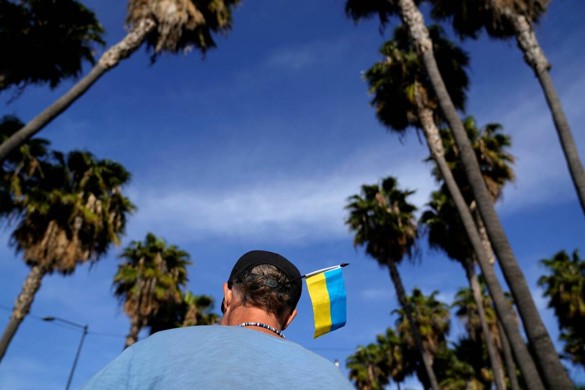 Volunteer Zank Bennett, of the United States, wears a Ukrainian flag in his hat as he helps Ukr ...