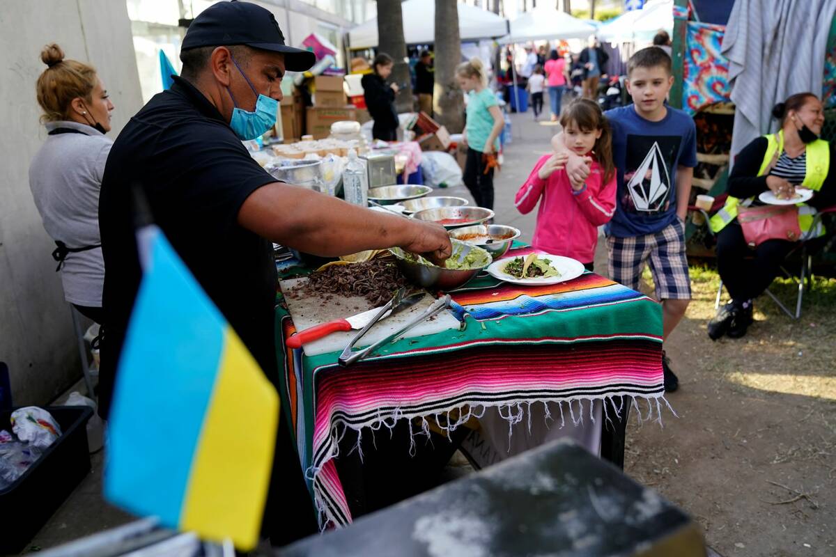 Mexican volunteer Felix Lara prepares tacos for Ukrainians refugees at a makeshift camp near th ...