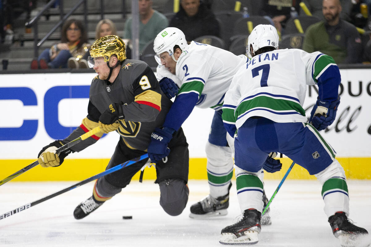 Golden Knights center Jack Eichel (9) loses control of the puck to Canucks defenseman Luke Sche ...