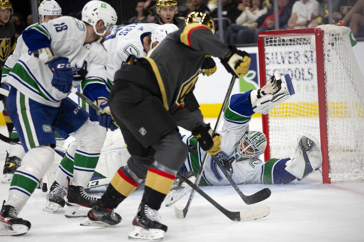 Canucks goaltender Thatcher Demko (35) dives to save a shot by Golden Knights center Chandler S ...