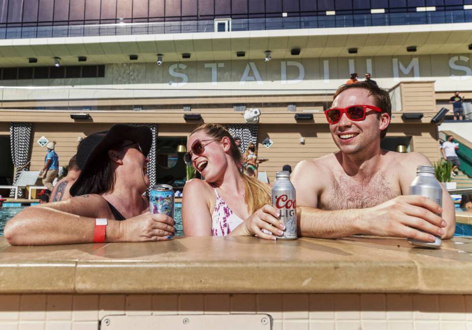 Stacy Sheridan, left, Katie Hatfield and Tom Rollag, from Minneapolis, Minn., enjoy the pool at ...