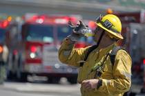 Firefighter Ernesto Naranjo takes a drink break while battling a brush fire along the 118 freew ...