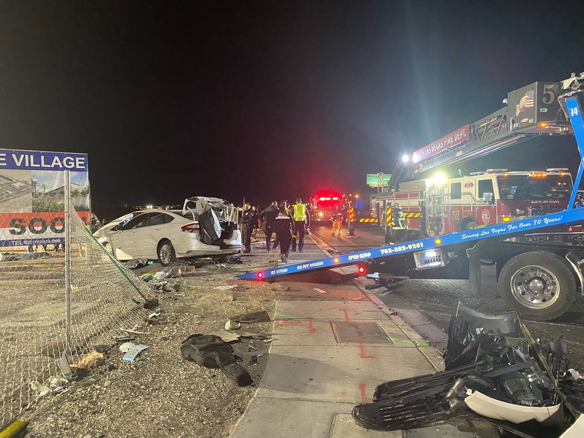 Authorities get set to tow a vehicle involved a six-car crash at the scene of a fatal crash on ...