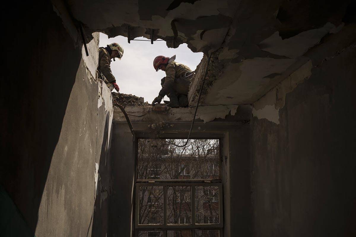 Firefighters work to secure a building previously damaged by a Russian attack in Kharkiv, Ukrai ...