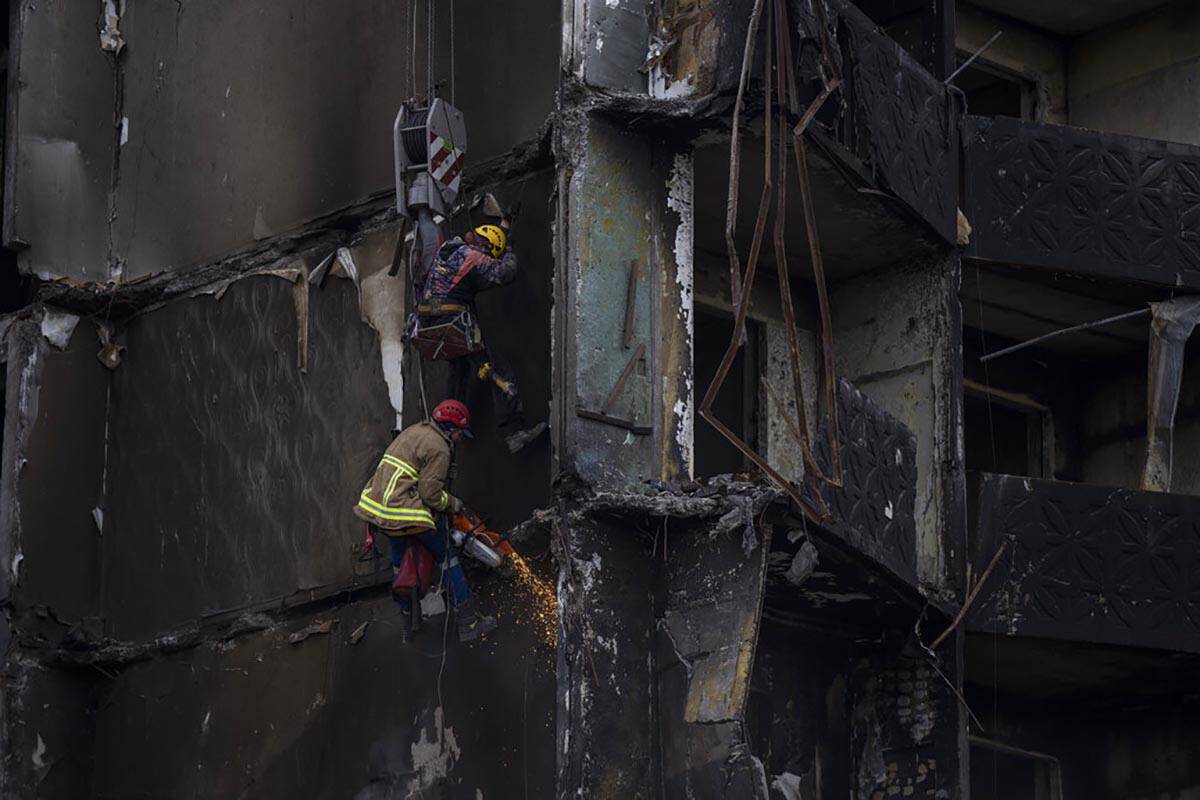 Firefighters work on a destroyed apartment building in the town of Borodyanka, Ukraine, on Satu ...