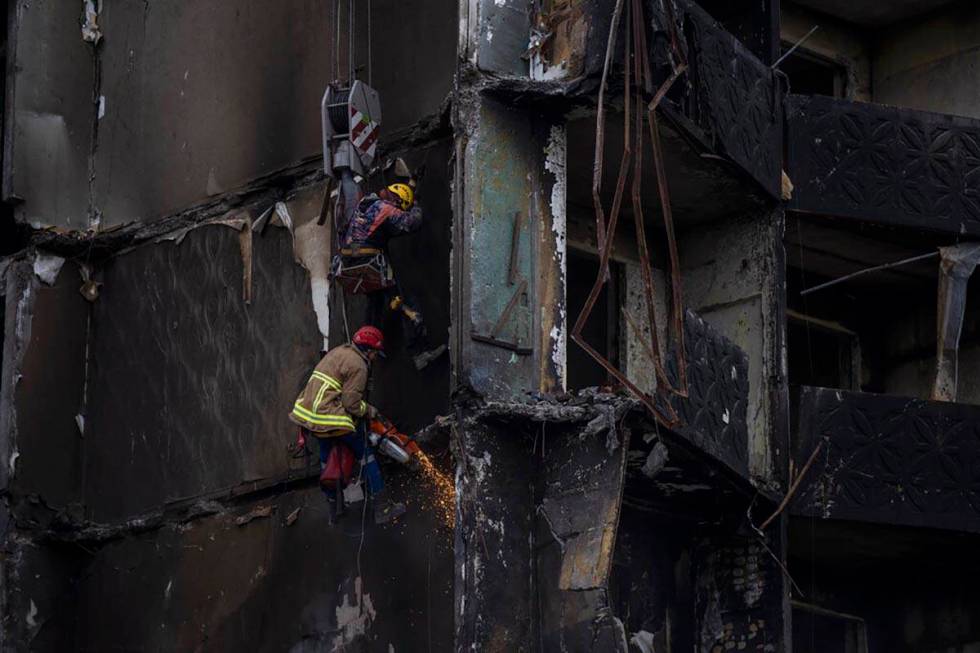 Firefighters work on a destroyed apartment building in the town of Borodyanka, Ukraine, on Satu ...