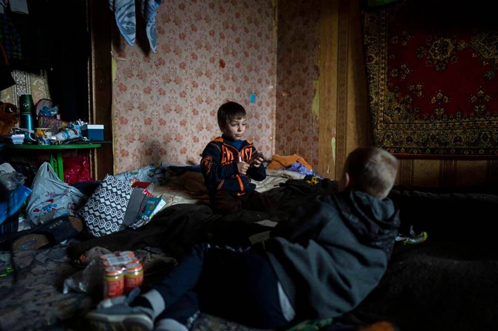 Vlad, 6, plays cards with a friend inside his house in Bucha, in the outskirts of Kyiv, Ukraine ...