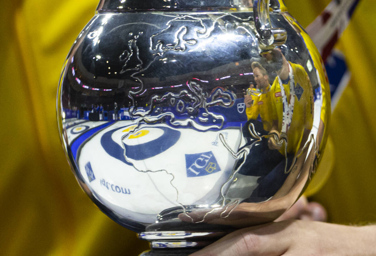 Members of Sweden’s national team are reflected in the trophy after defeating Canada in ...