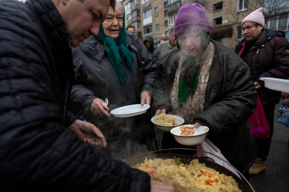 Neighbours receive free food from a soup kitchen in Bucha, in the outskirts of Kyiv, Ukraine, S ...