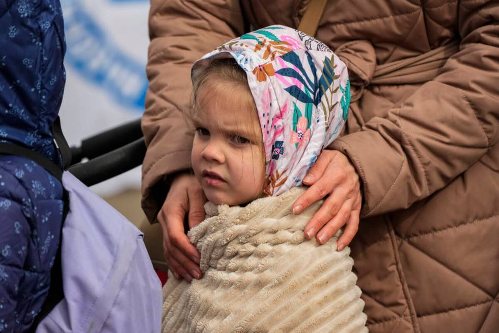 A refugee child waits in a line after fleeing the war from neighboring Ukraine at the border cr ...