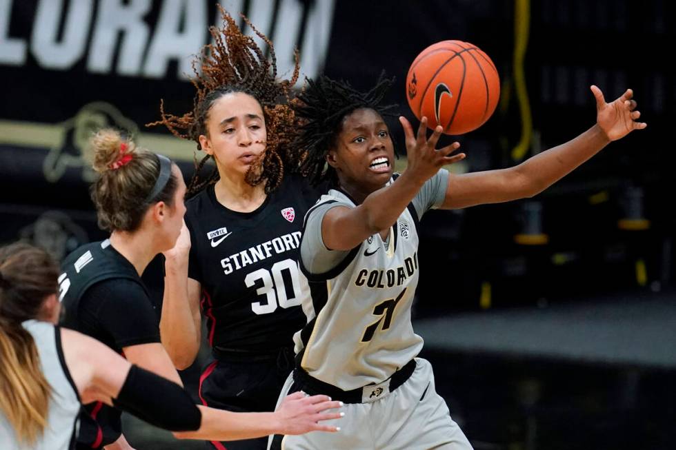 Colorado guard Mya Hollingshed, right, pulls in a rebound as Stanford guards Lexie Hull, left, ...