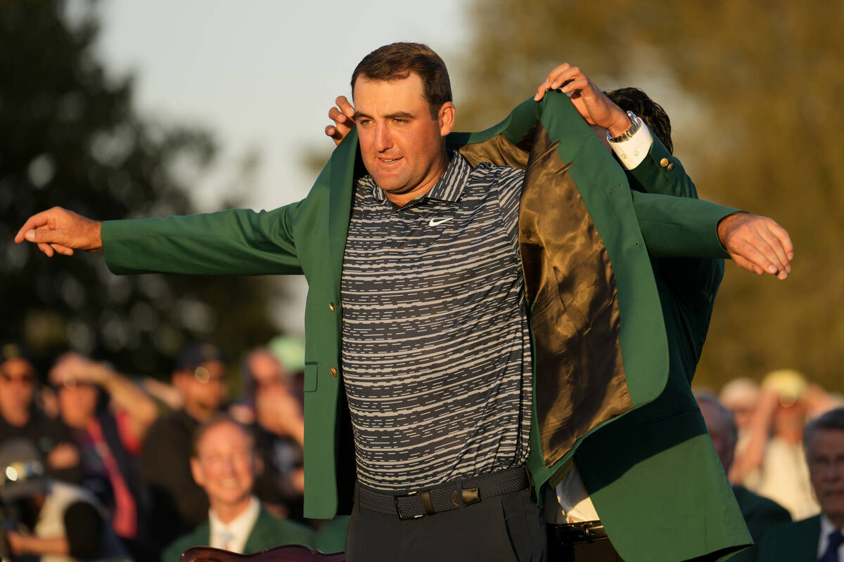 Hideki Matsuyama, of Japan, helps Scottie Scheffler put on the green jacket after winning the 8 ...