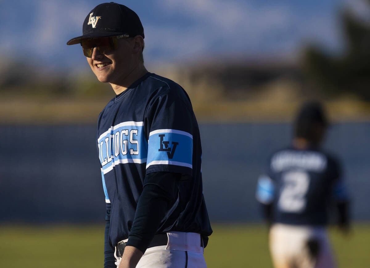 Centennial’s Logan Smith (44) shares a laugh with an umpire (out of frame) during a boys ...