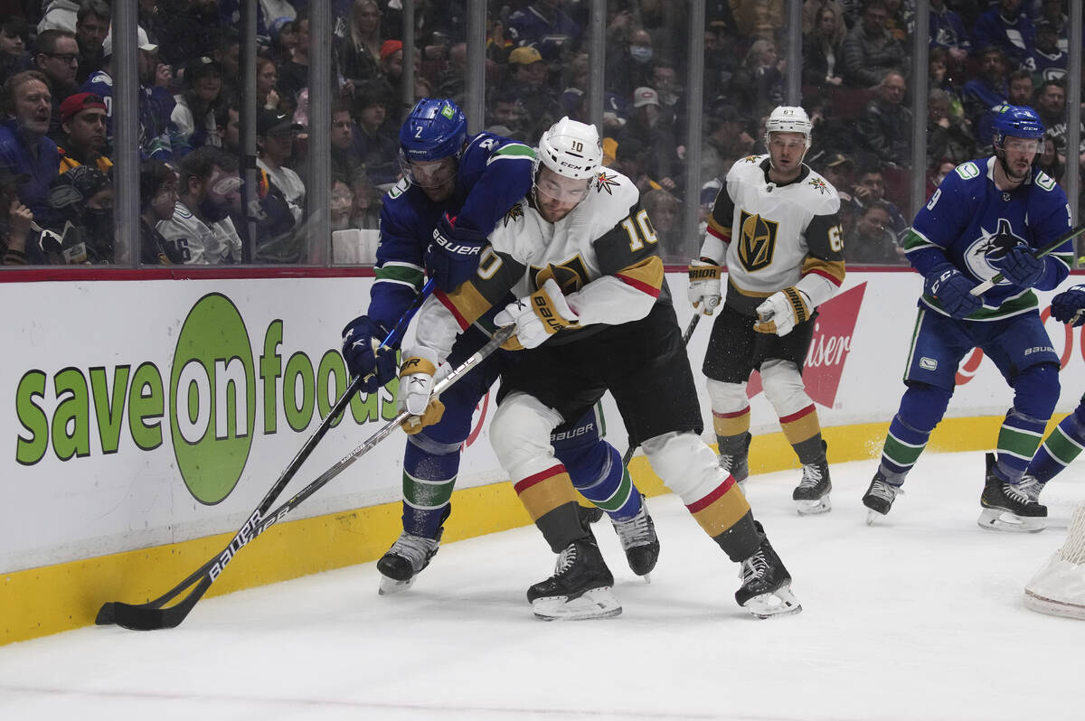 Vancouver Canucks' Luke Schenn (2) and Vegas Golden Knights' Nicolas Roy (10) vie for the puck ...