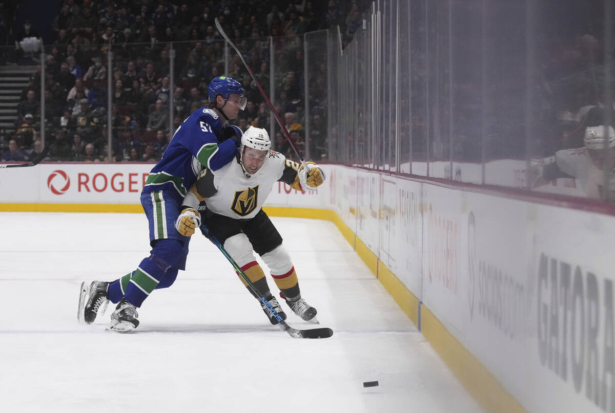 Vancouver Canucks' Tyler Myers, left, checks Vegas Golden Knights' Michael Amadio during the se ...
