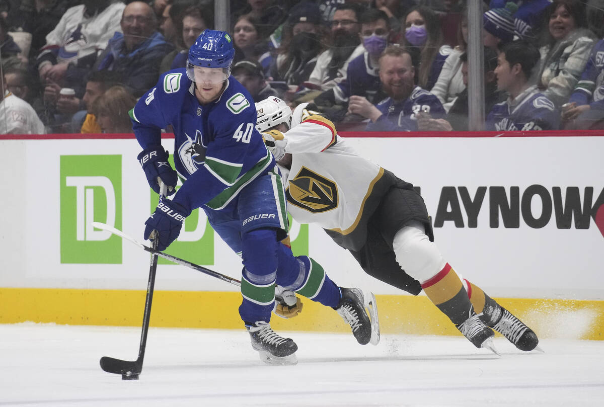 Vancouver Canucks' Elias Pettersson skates with the puck away from Vegas Golden Knights' Chandl ...