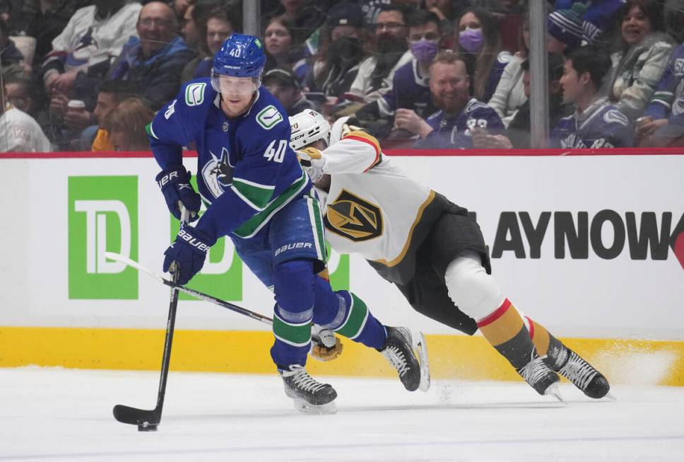 Vancouver Canucks' Elias Pettersson skates with the puck away from Vegas Golden Knights' Chandl ...
