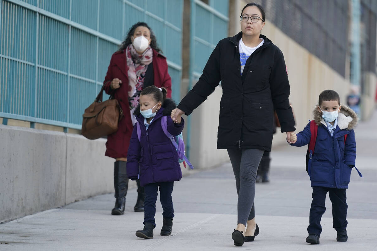 Children and their caregivers arrive for school in New York, Monday, March 7, 2022. The Biden ...