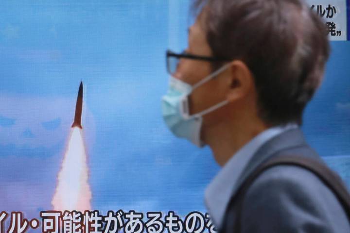 A man walks past a TV screen showing a news program reporting about North Korea's missile launc ...
