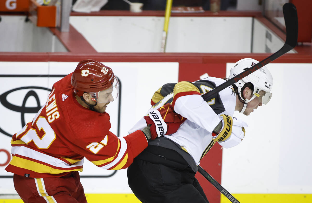 Vegas Golden Knights' Nolan Patrick, right, is hooked by Calgary Flames' Trevor Lewis during th ...