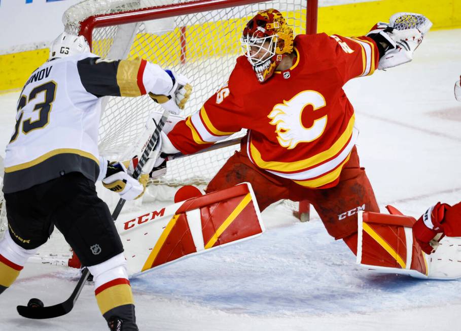 Vegas Golden Knights' Evgenii Dadonov, left, scores against Calgary Flames goalie Jacob Markstr ...