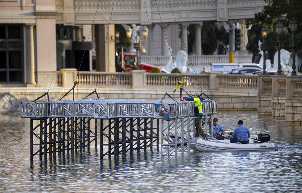 The first piece for the NFL Draft red carpet stage is lowered onto the water at the Bellagio Fo ...