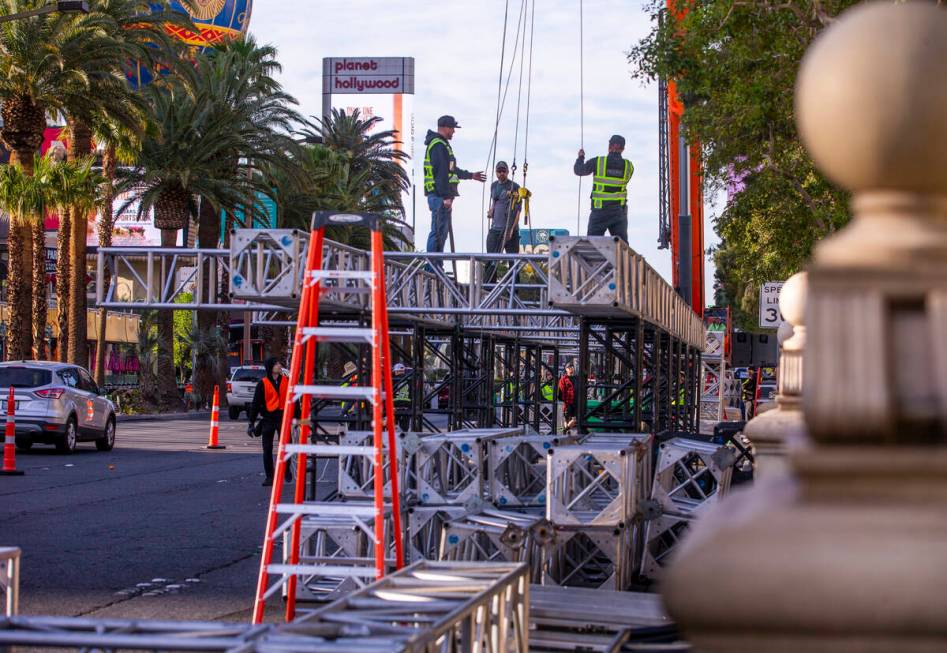 A construction crew readies to lift the second piece for the NFL Draft red carpet stage to be l ...