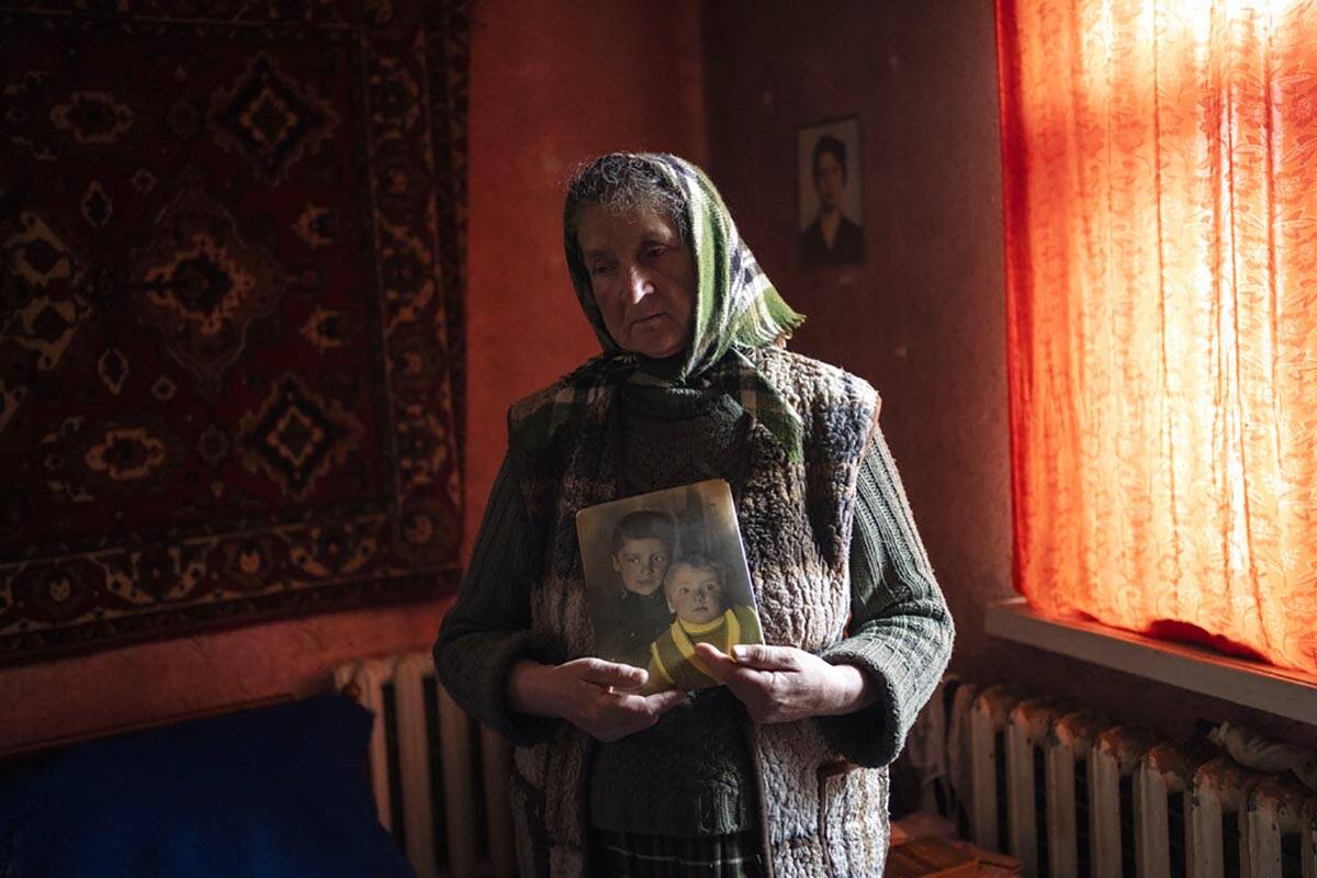 Nadiya Trubchaninova, 70, stands in her bedroom holding a portrait of her sons Oleg Trubchanino ...