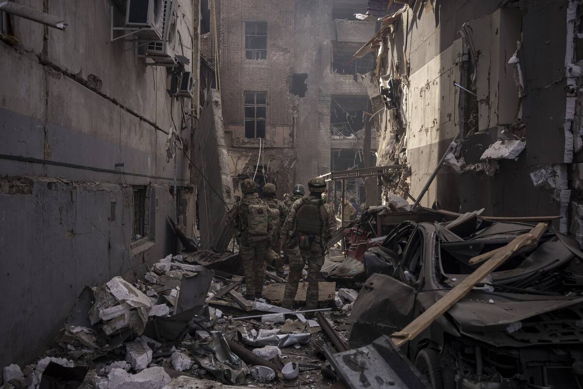 Ukrainian servicemen walk among debris of damaged buildings after a Russian attack in Kharkiv, ...