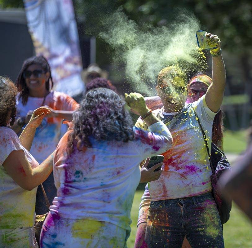 Adrian Gebilaguin, right, throws some color along with friend Virginia Montilla and others duri ...
