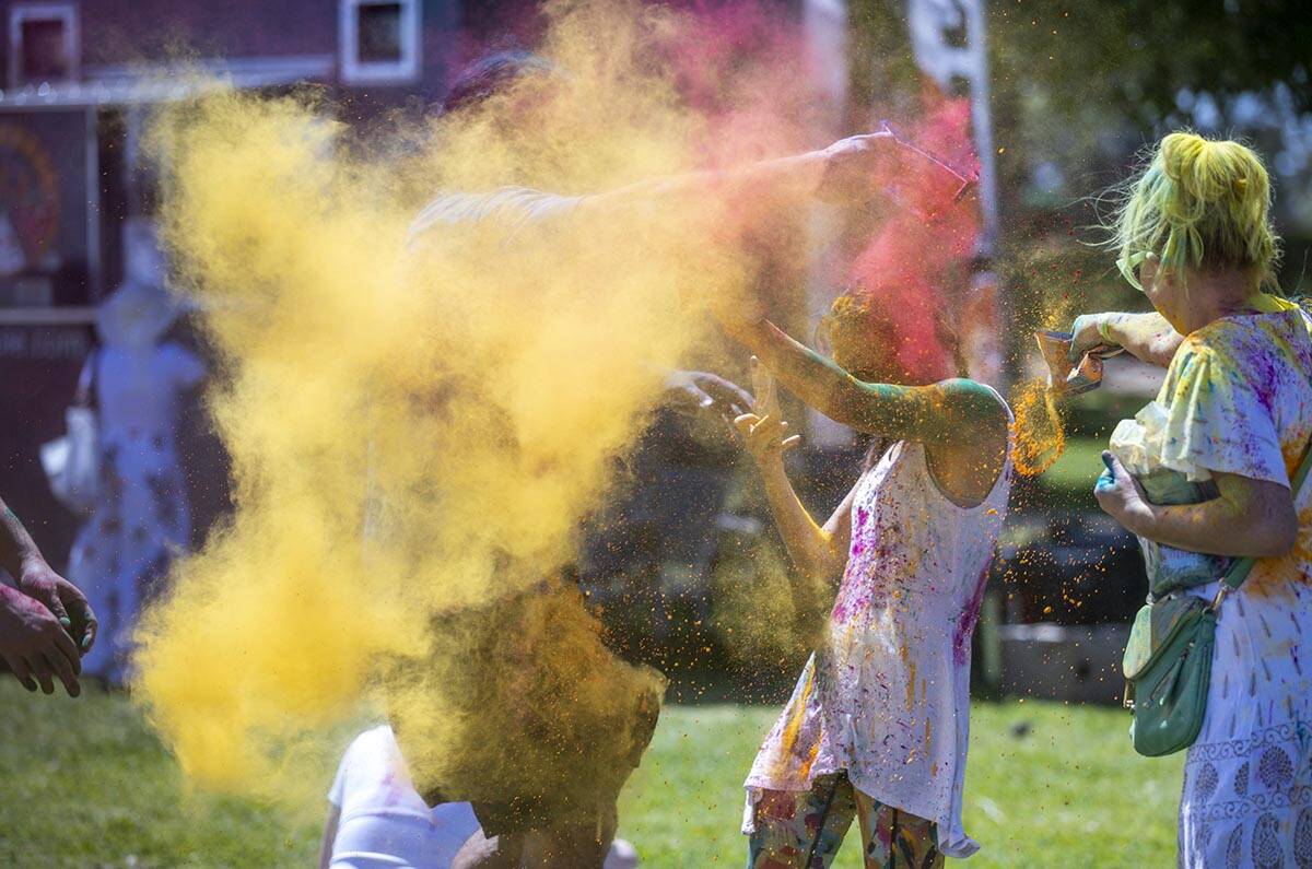 People throw some colors at each other as the music plays during the Holi Festival of Colors at ...