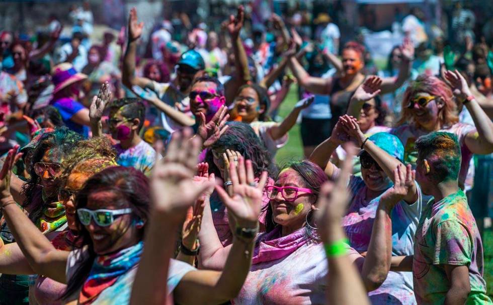 Participants follow a dancer on stage during the Holi Festival of Colors which features music, ...