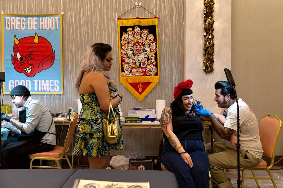 Carolina Franco, center right, has a clown tattooed on her by Pancho in the Tattoo Saloon durin ...