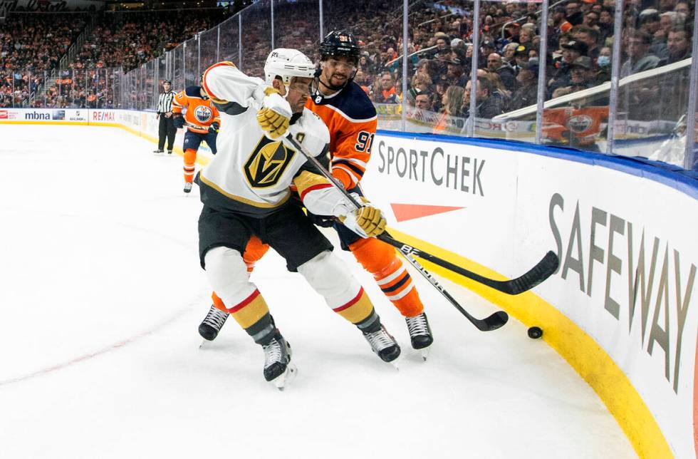 Vegas Golden Knights' Alec Martinez (23) and Edmonton Oilers' Evander Kane (91) battle for the ...