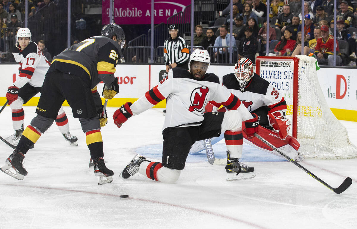 Golden Knights defenseman Shea Theodore (27) is blocked from shooting by New Jersey Devils defe ...